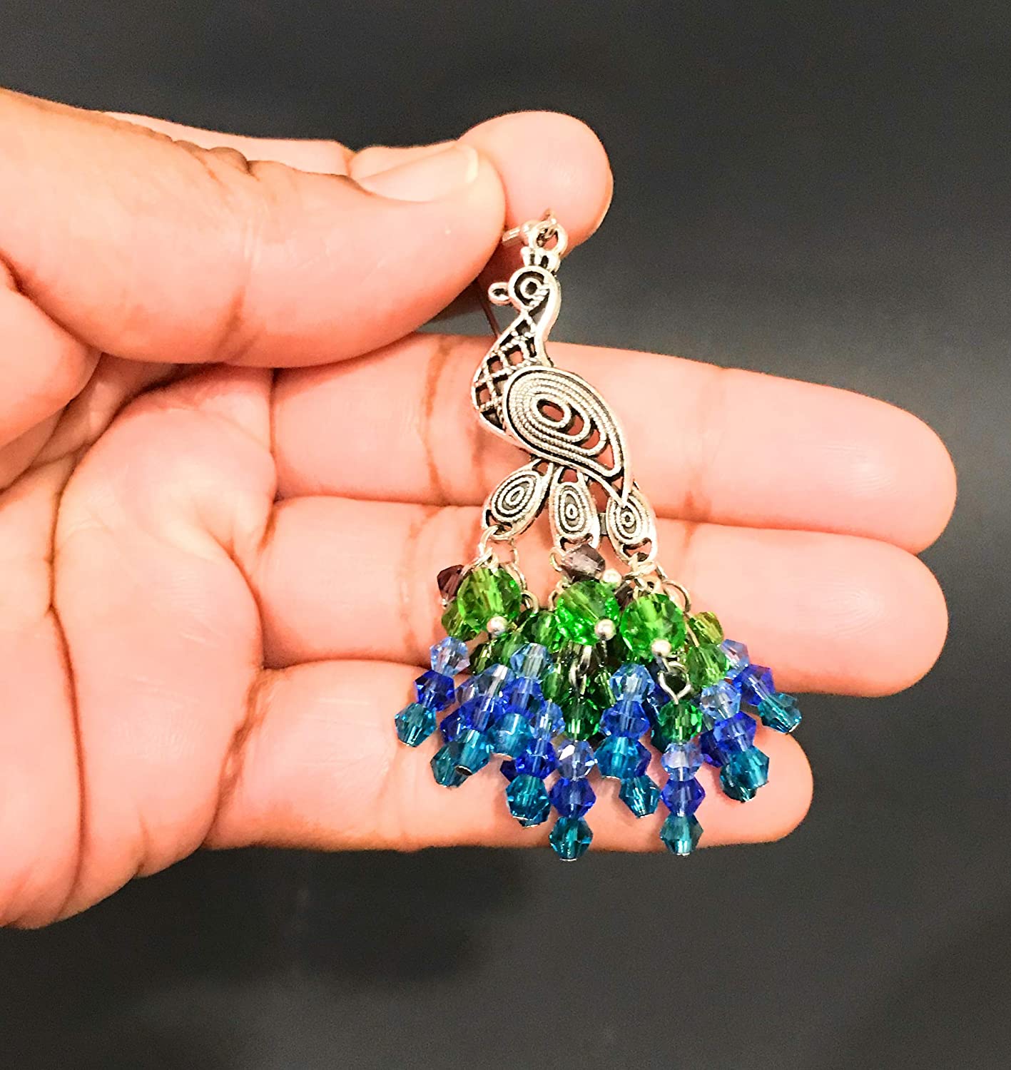Peacock Chandelier Dangle Earrings in a Womans Hand at Scott D Jewelry Designs