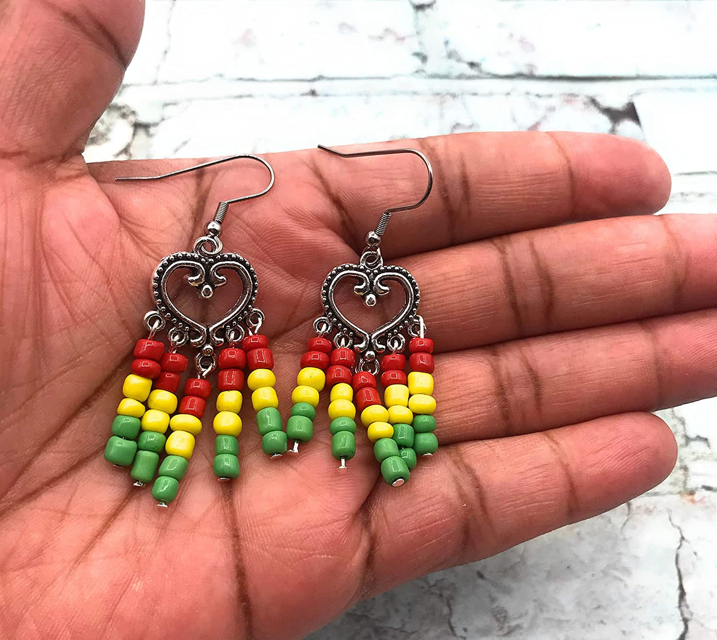 Rasta earrings in red yellow and green in the palm of a hand from Scott D Jewelry Designs